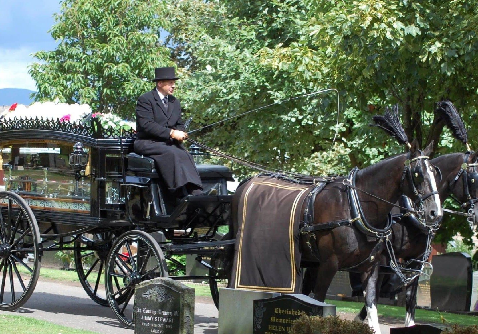 Man on horse drawn carriage with coffin in Falkirk