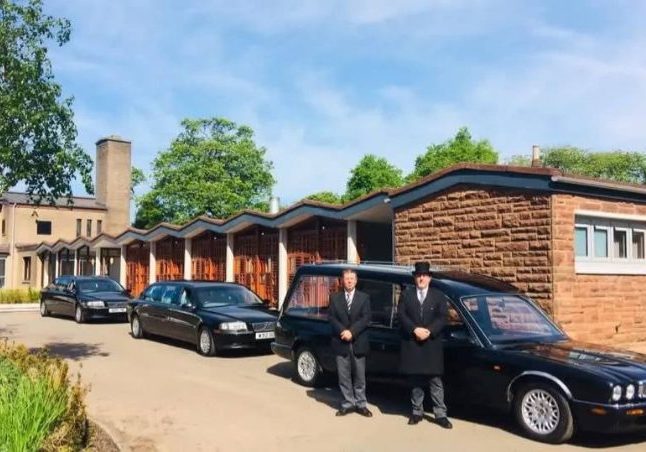 2 men standing outside a funeral directors in Falkirk