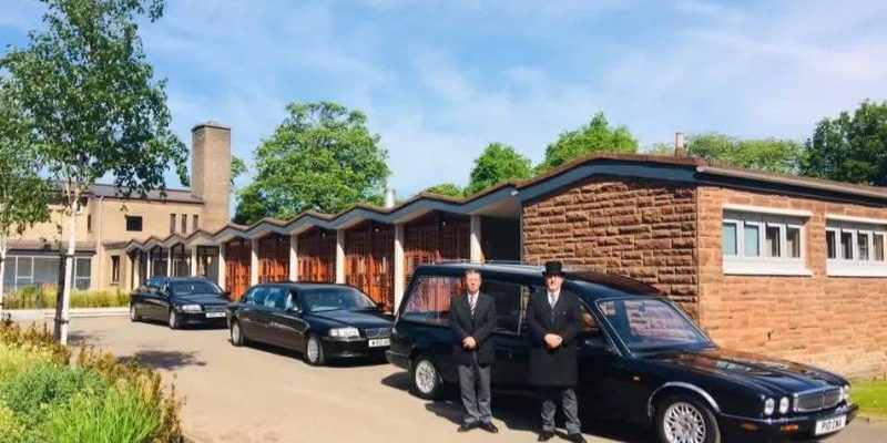 2 men standing outside a funeral directors in Falkirk